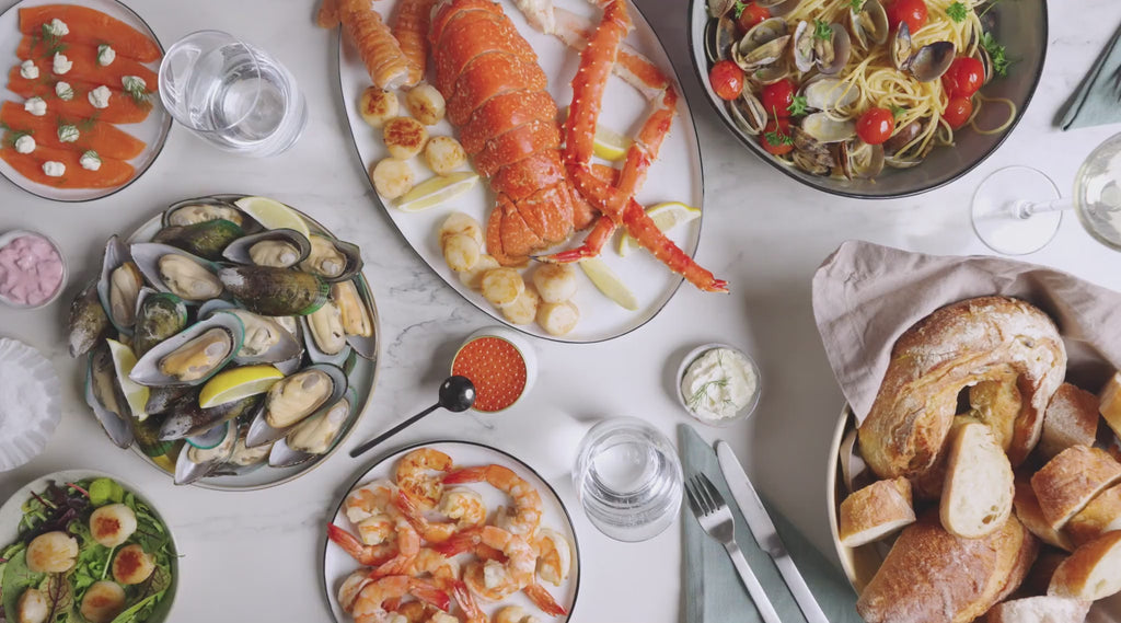 Seafood mit Hummer, Muscheln, Garnelen und Lachs auf festlich gedeckten Tisch